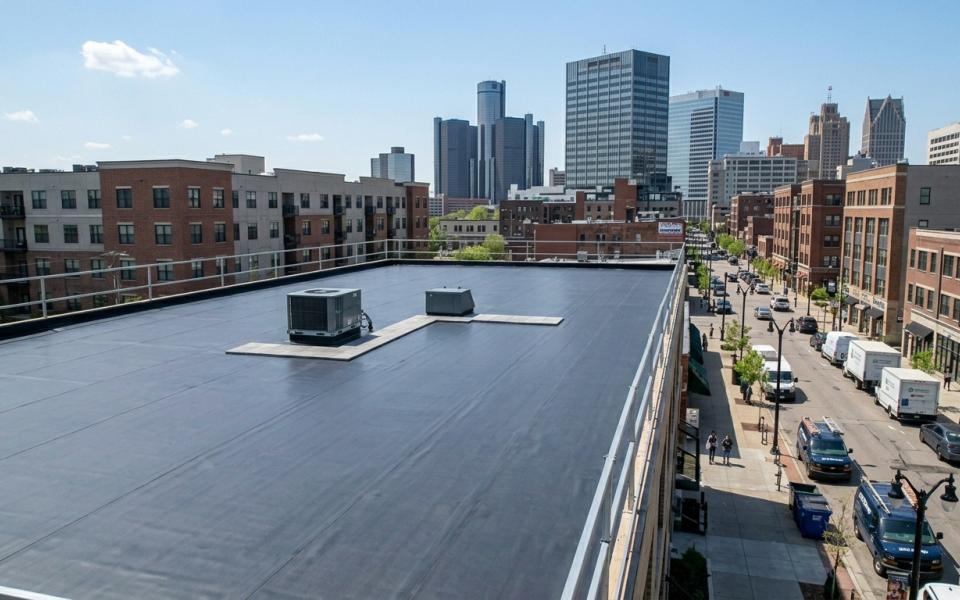 Contractor inspecting a residential asphalt roof during the fall season