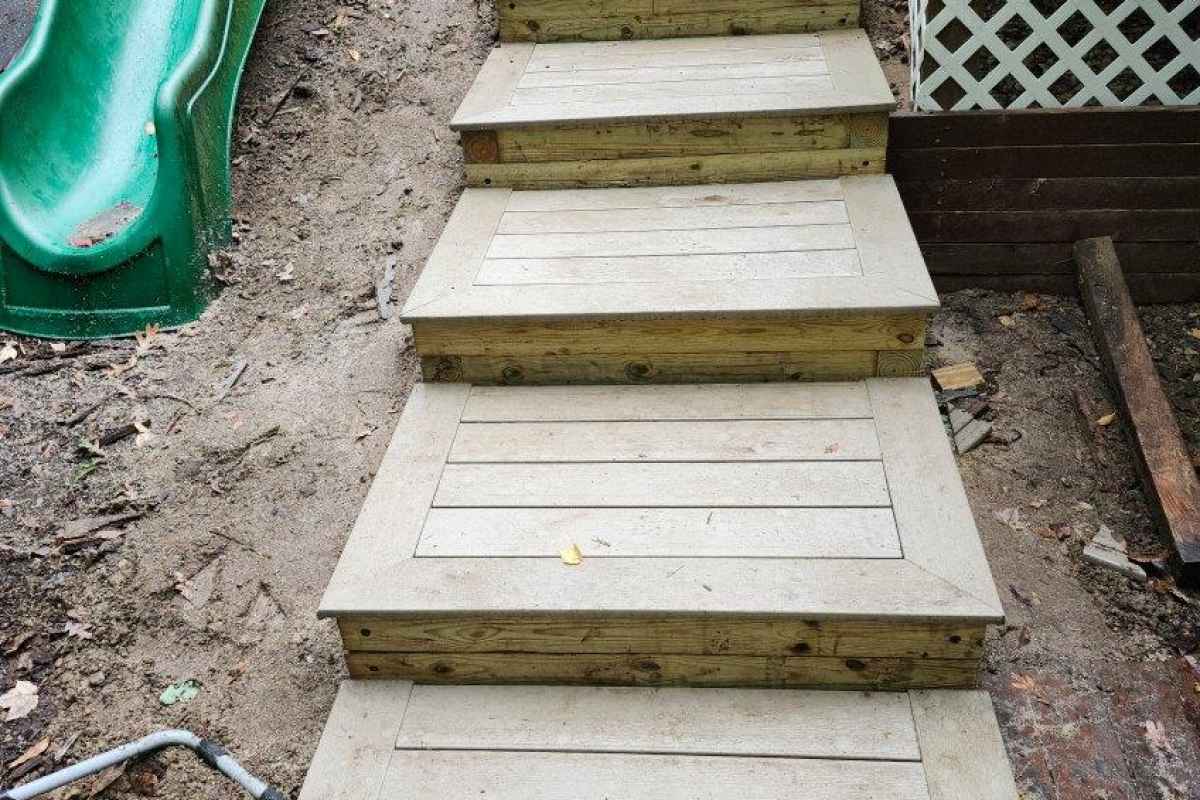 Custom exterior stairs with composite treads built into a sloped backyard.
