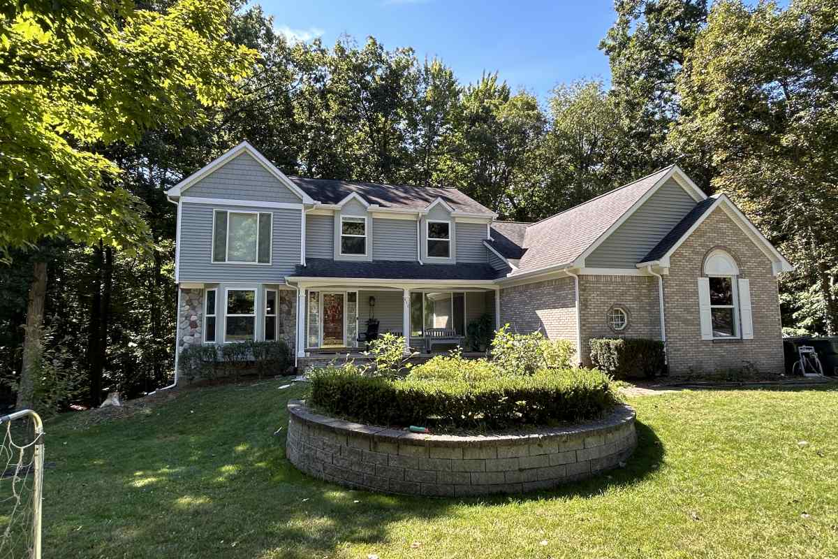 A modernized home exterior featuring painted brick and new siding